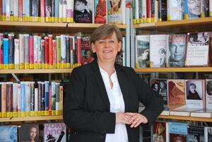 Bild vergr&ouml;&szlig;ern: Büchereileitung Wiebke Kuchel steht vor einem Bücherregal.
