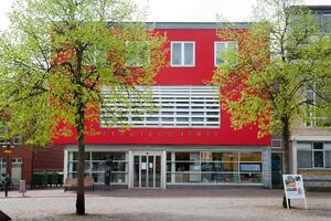 Bild vergr&ouml;&szlig;ern: Zu sehen ist der Eingangsbereich der Stadtbücherei, die Fassade ist in Rot gestrichen.