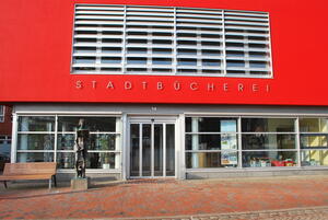 Bild vergr&ouml;&szlig;ern: Zu sehen ist der Eingangsbereich der Stadtbücherei, die Fassade ist in Rot gestrichen.