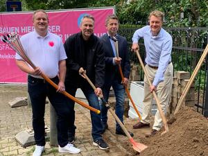 Bild vergr&ouml;&szlig;ern: Vier Herren stehen mit einem Glasfaserkabel und Spaten vor einem Sandhaufen. Die Herren sind von links nach rechts Carsten Hartung, Telekom, Patrick Pingel, Telekom, Jürgen Hüning, VolkerWessels Telecom GmbH und Bürgermeister Dr. Brinkmann