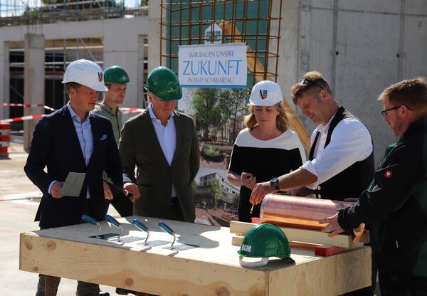Der Bürgermeister, Herr Wulff und Frau Zweig beobachten, wie die Zeitkapsel von einem Mitarbeiter der Firma verlötet wird.