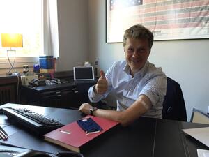 Bild vergr&ouml;&szlig;ern: Bürgermeister Dr. Brinkmann sitzt in seiner Amtsstube, hat den linken Hemdsärmel hochgekrempelt, dort sieht man ein Pflaster kleben. Mit der rechten Hand streckt er den Daumen hoch.