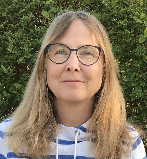 Bild vergr&ouml;&szlig;ern: Frau Heidemann trägt einen Ringelpulli, eine Brille und hat schulterlanges, blondes Haar. Sie lächelt leicht in die Kamera.