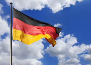 Bild vergr&ouml;&szlig;ern: Die Deutschlandfahne weht im Wind, am blauen Himmel sieht man weiße Wolken.